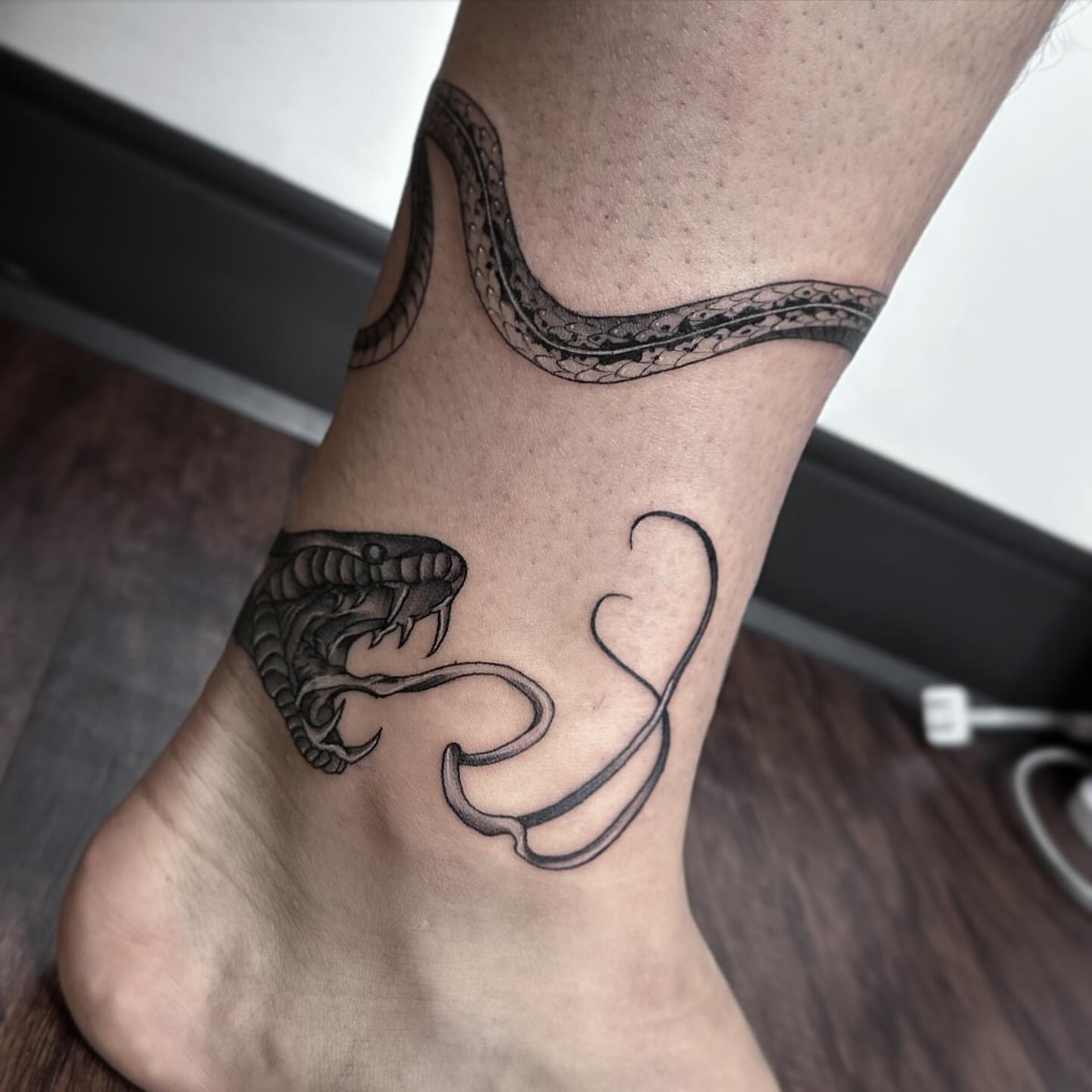 Snake black and grey tattoo on the foot by Rachel Martinez
