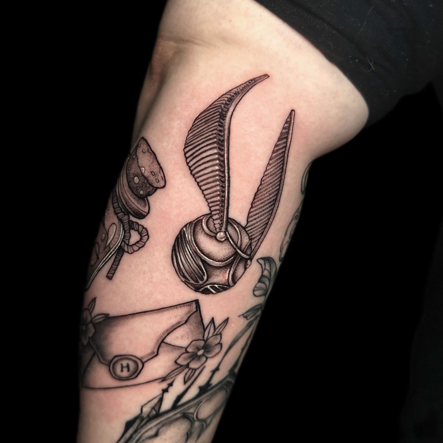 Golden snitch black and grey tattoo on the forearm by πΊπππππ βΎ π»πππππ π¨πππππ