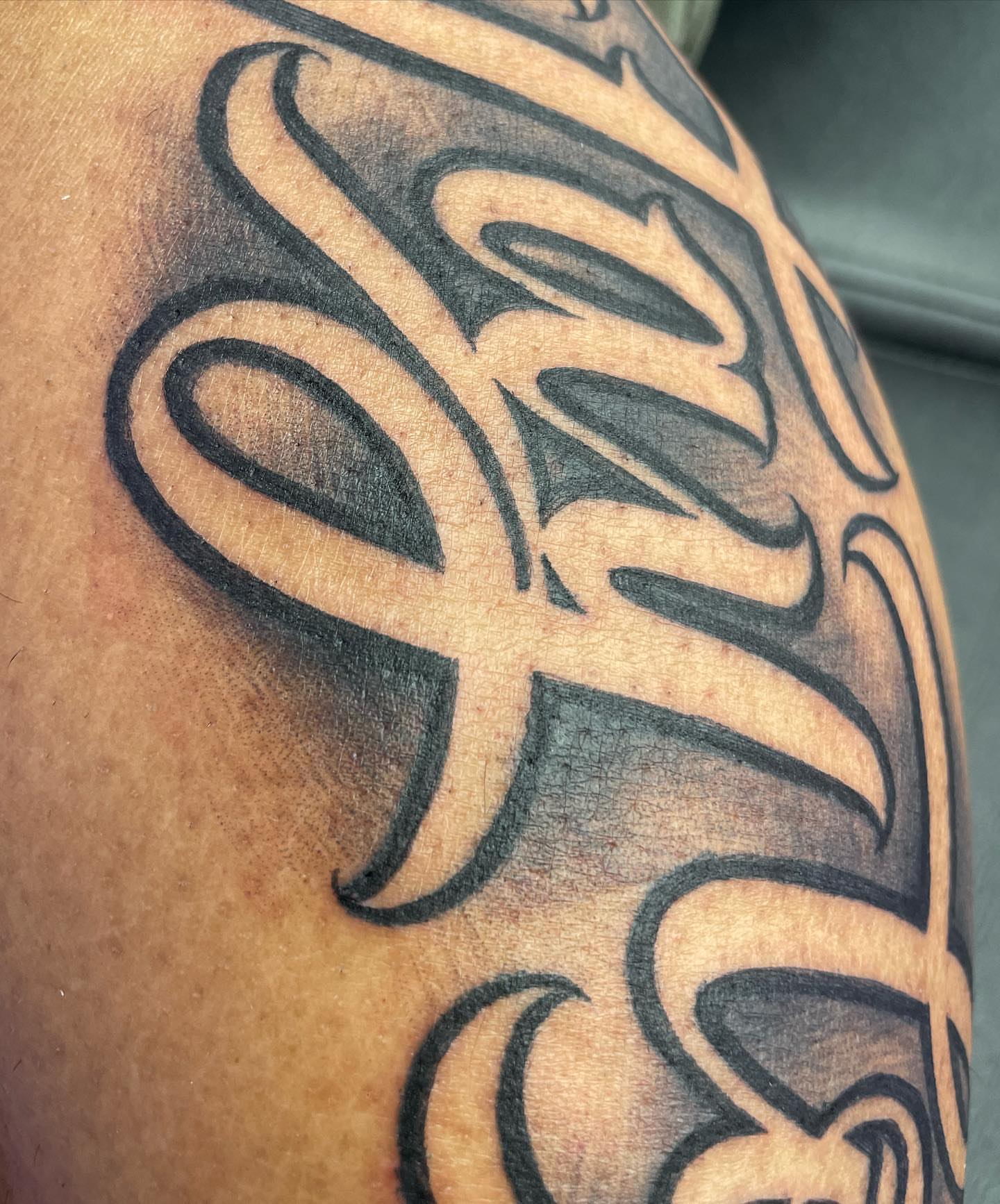 Script lettering lettering script tattoo on the upper arm by Blake