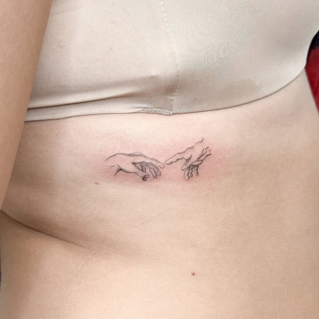 Hands reaching minimalist tattoo on the torso by INK by CEE
