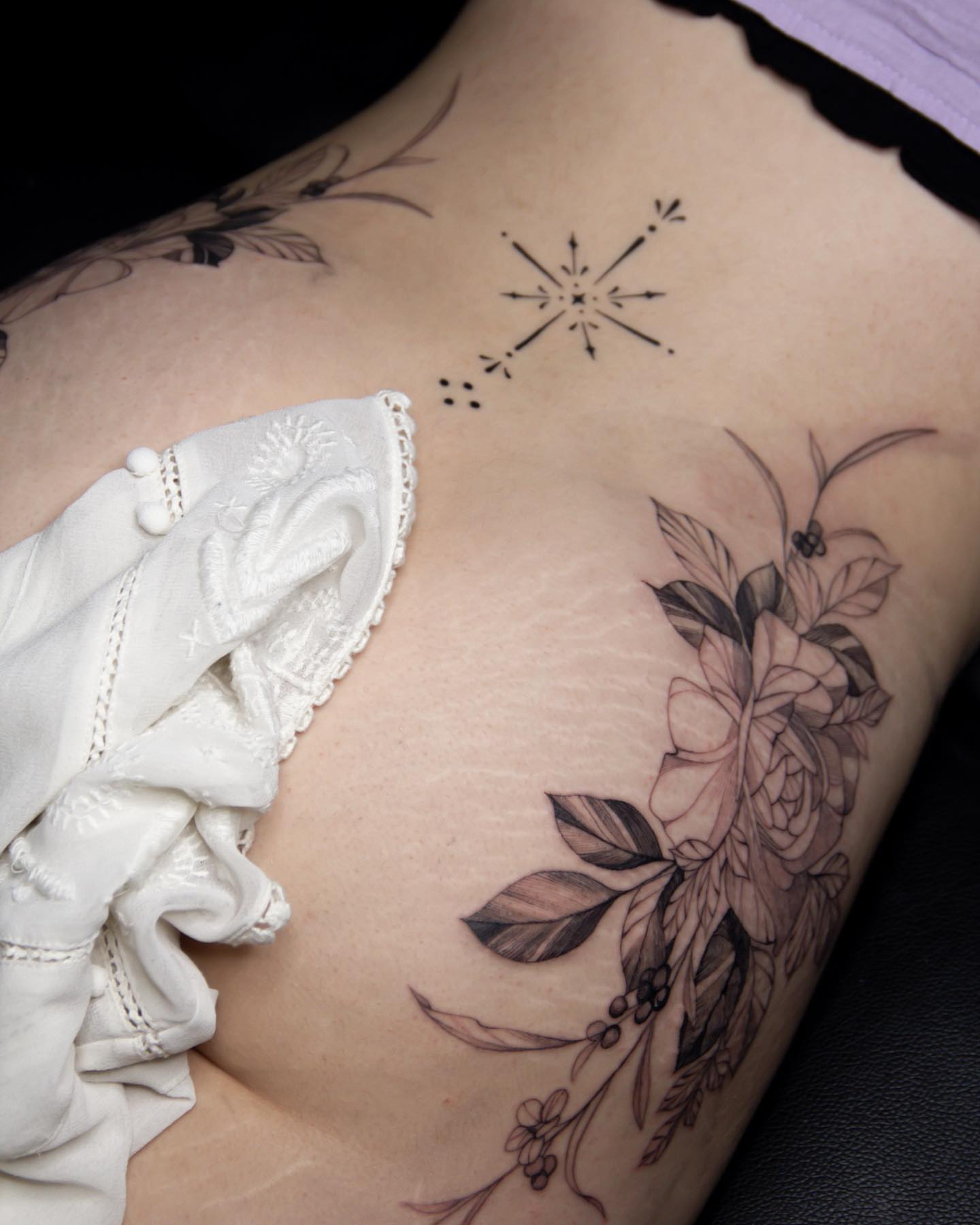 Floral bouquet black and grey tattoo on the ribs by Liv