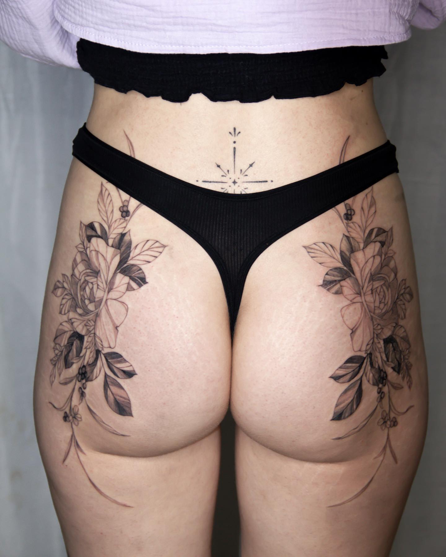 Floral bouquet black and grey tattoo on the thigh by Liv
