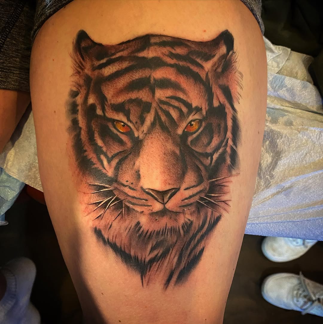Tiger face realism tattoo on the thigh by Cody Wolfe
