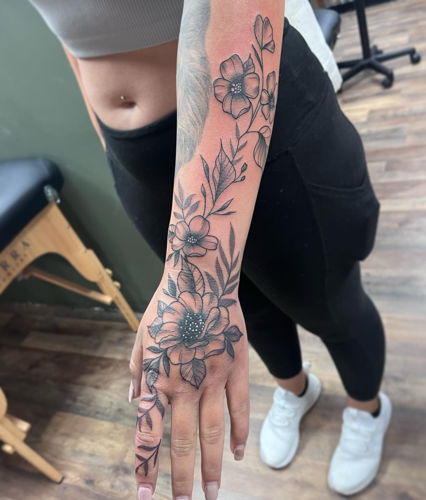 Floral arrangement black and grey tattoo on the hand by Waylen Foster
