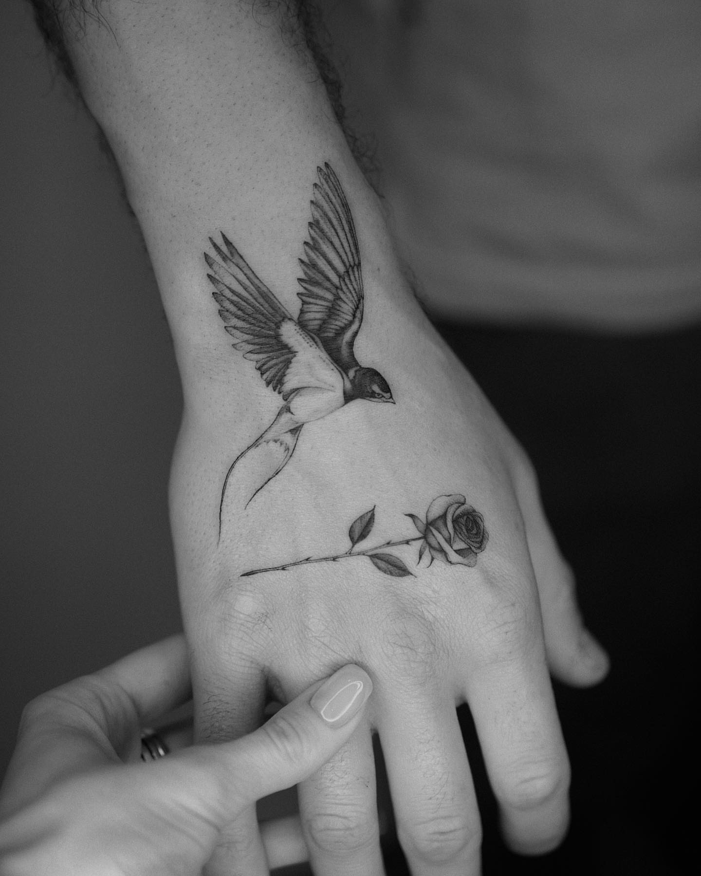 Bird and rose realism tattoo on the hand by Tattoo Artist