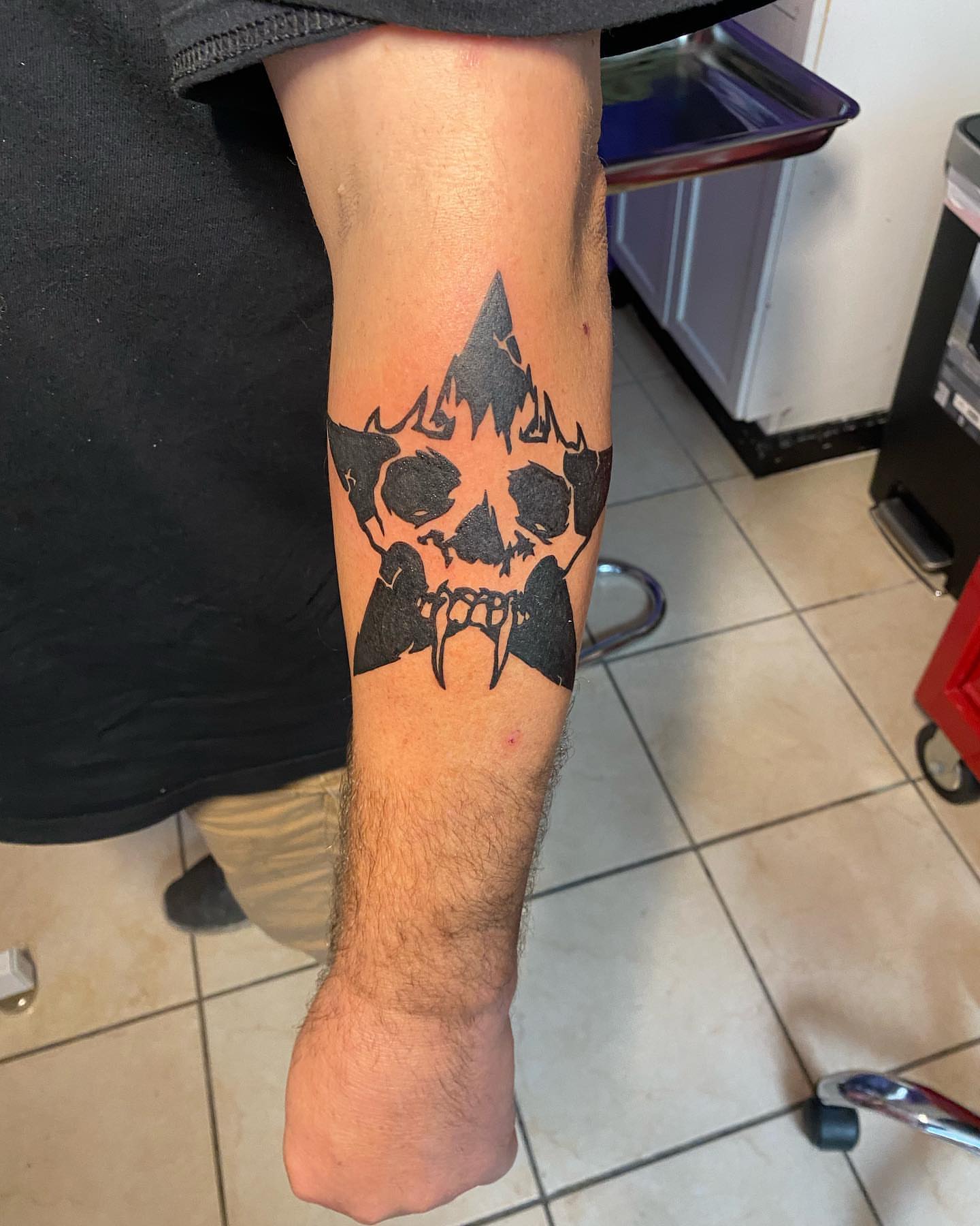 Skull black and grey tattoo on the forearm by Drew