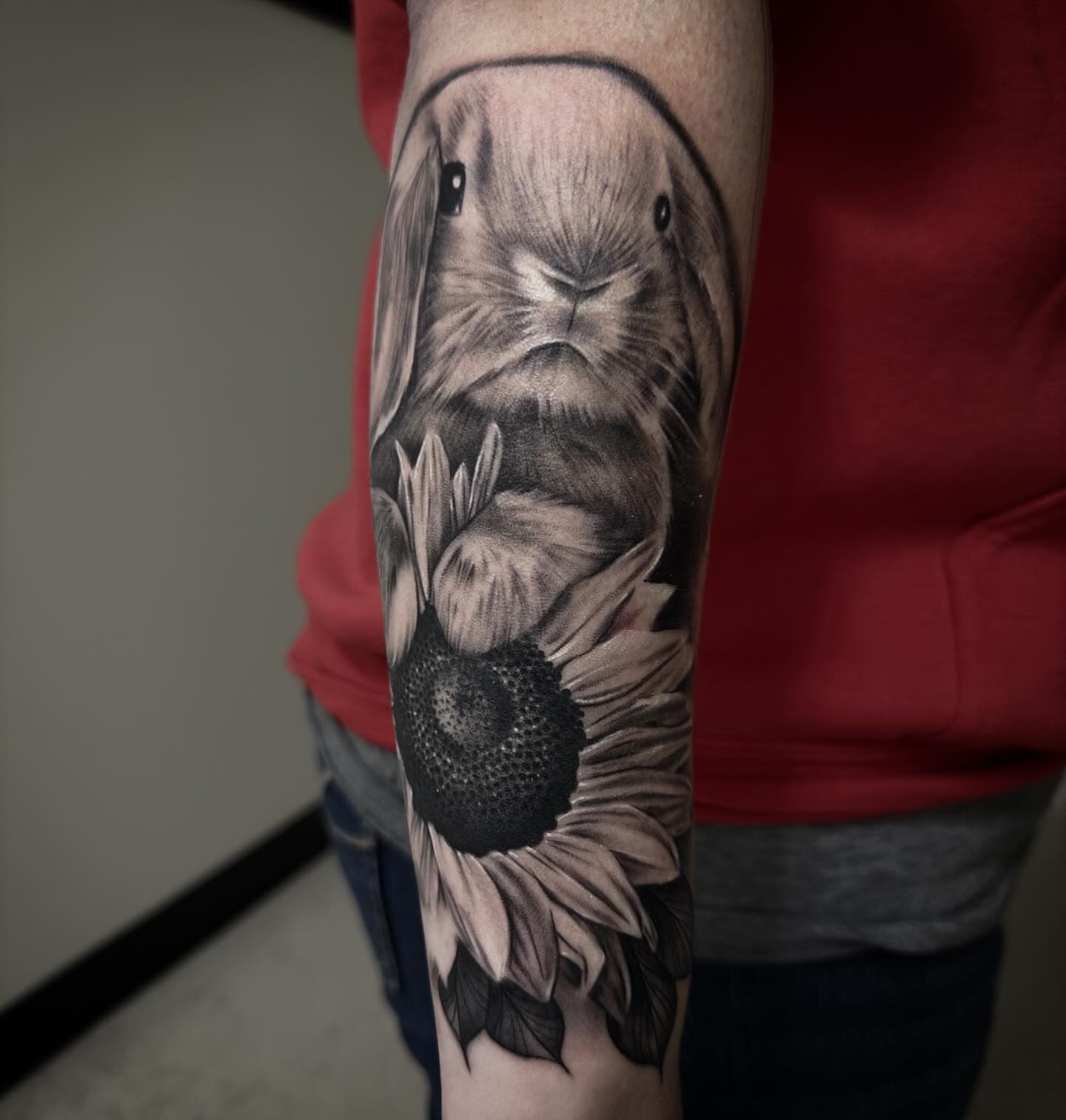 Sunflower and rabbit realism tattoo on the forearm by Dale DeVille