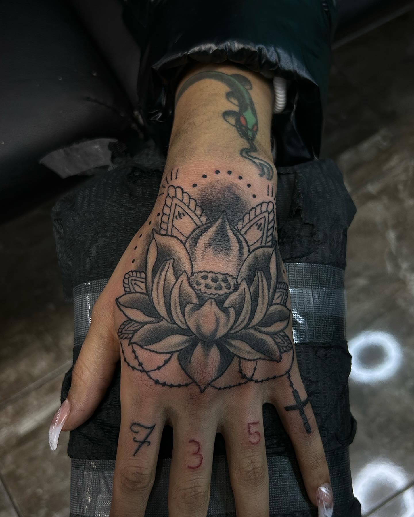 Lotus flower black and grey tattoo on the hand by Ares Rhodes