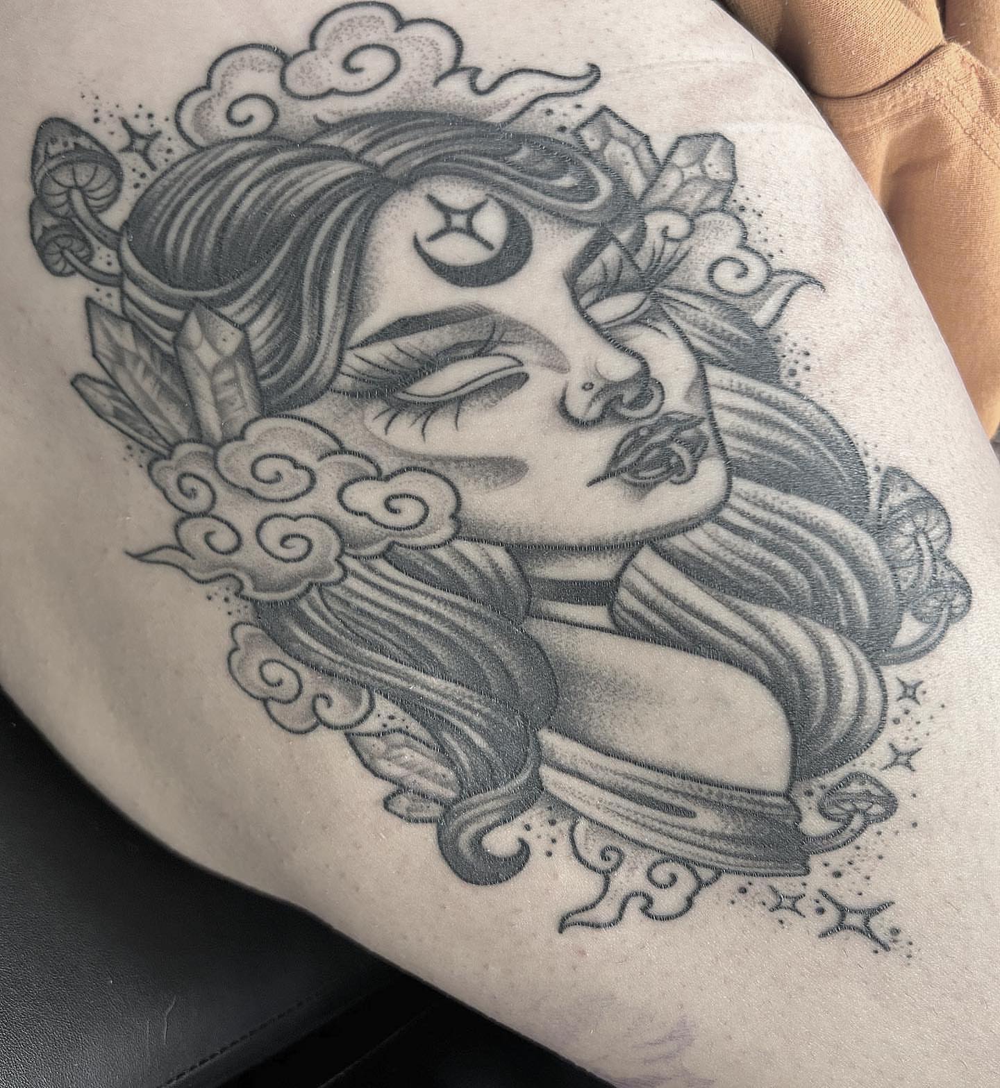 Woman's face black and grey tattoo on the thigh by Anna Nicole Thomas