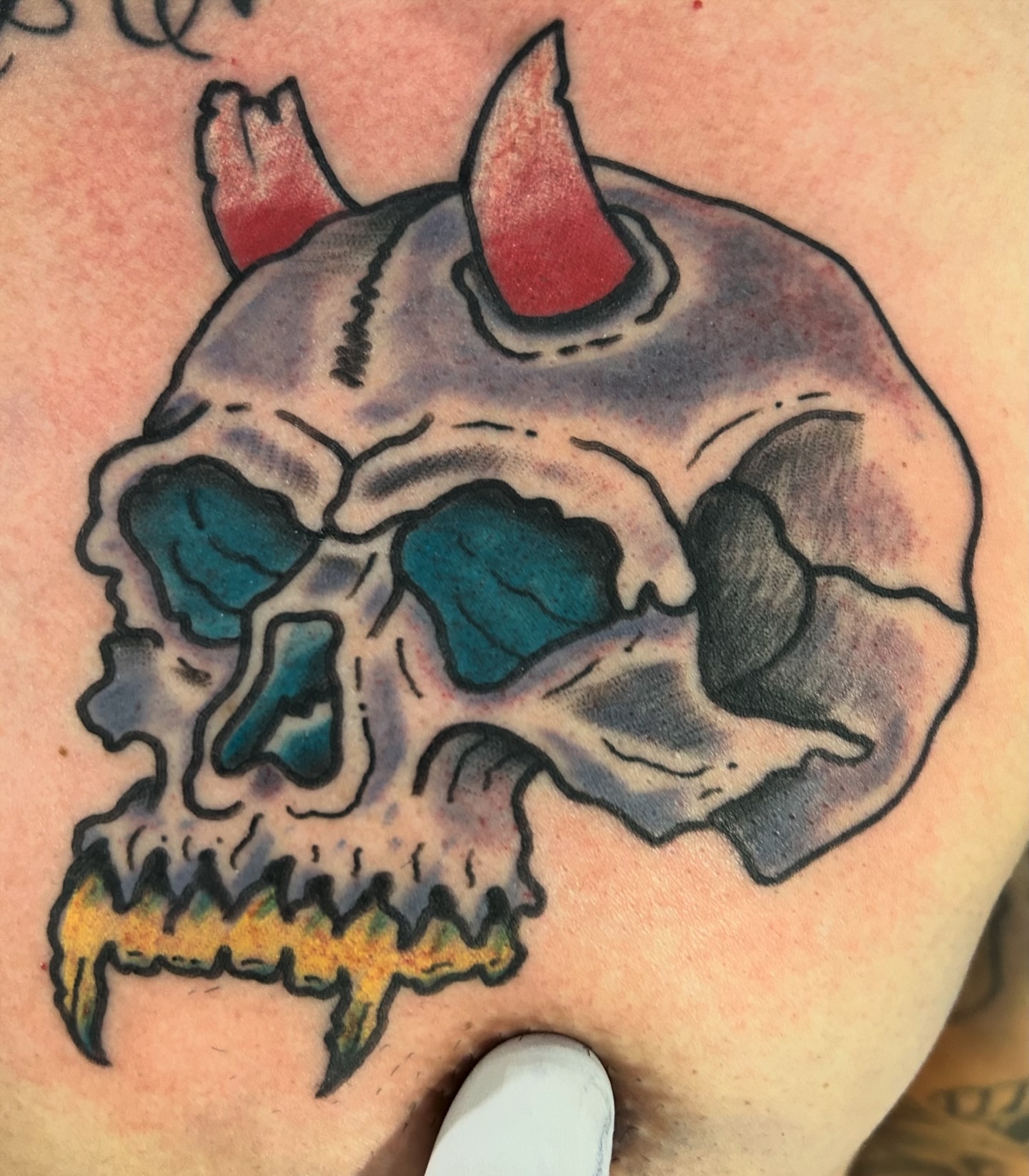 Skull American traditional tattoo on the shoulder by Alex Fannin