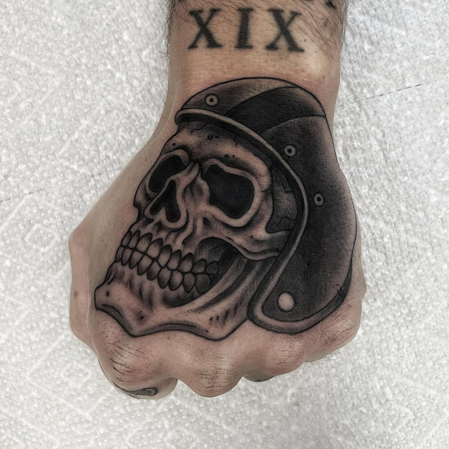 Skull with helmet realism tattoo on the hand by Pat Moser