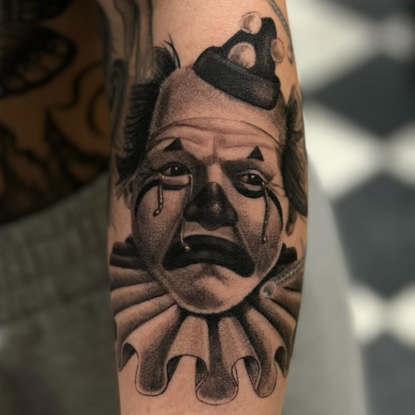 Clown realism tattoo on the forearm by Wolf of Wall St.