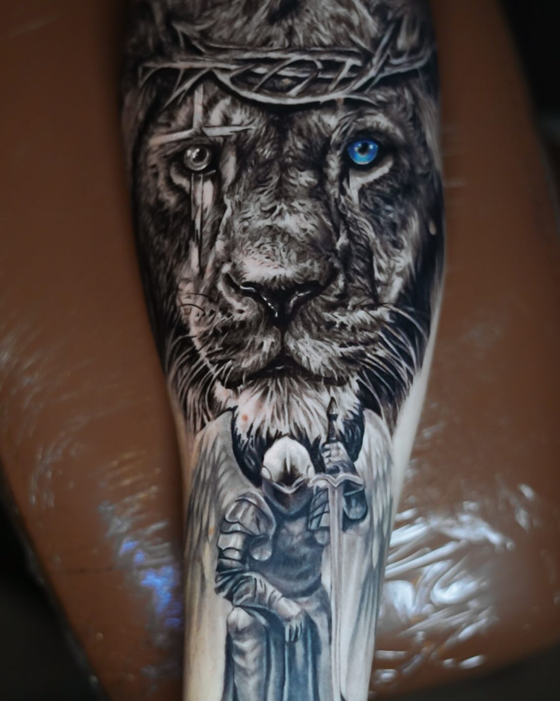 Lion and knight realism tattoo on the forearm by David Gordon