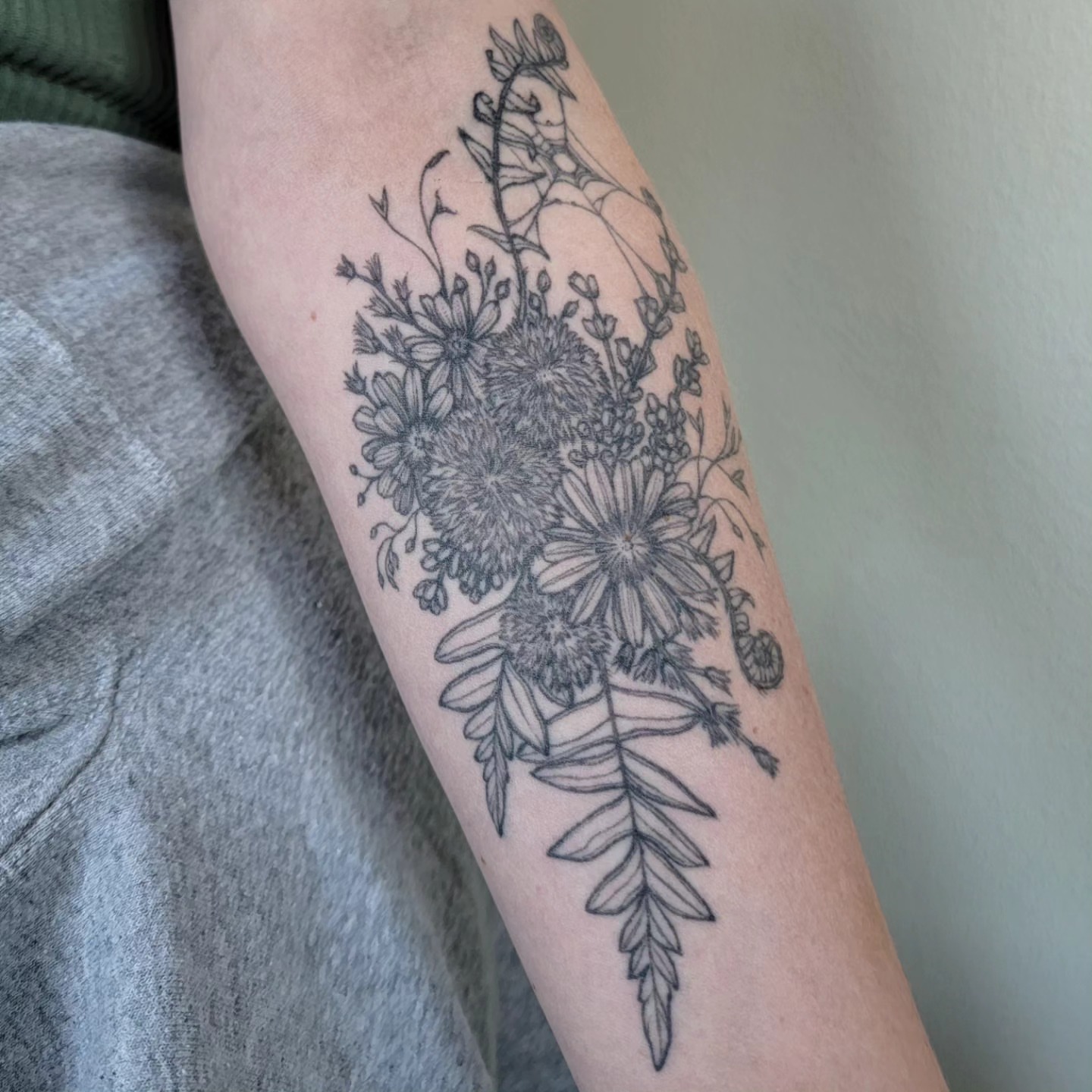 Floral bouquet black and grey tattoo on the forearm by Sierra (cc) Klein