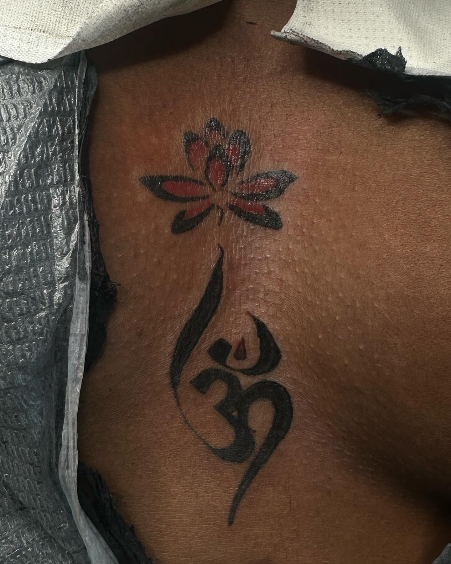 Lotus flower and om symbol tribal tattoo on the chest by Bay Area Tattoo Artist ✍🏽