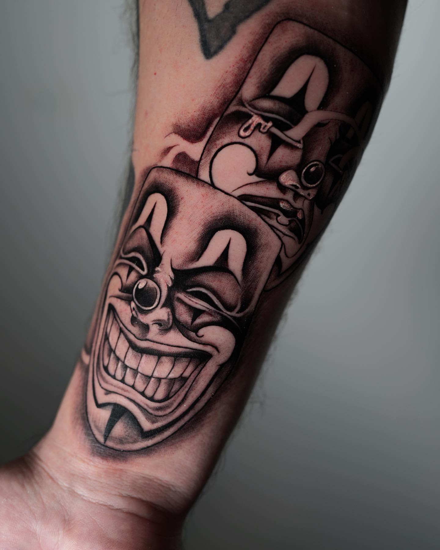 Clown face black and grey tattoo on the forearm by @katuvetattoo