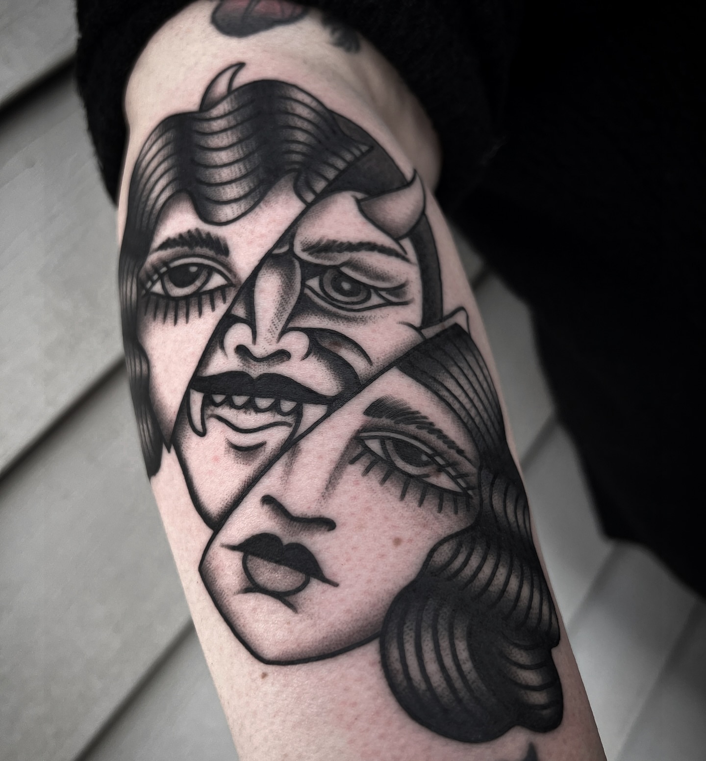 Abstract faces American traditional tattoo on the forearm by Daniel Mesen