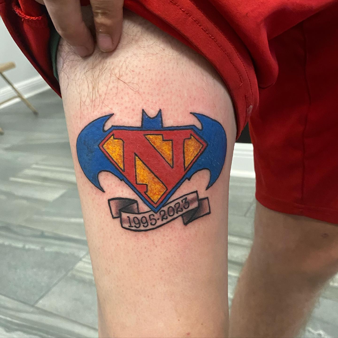Superhero logo new school tattoo on the thigh by Missy (Miz)