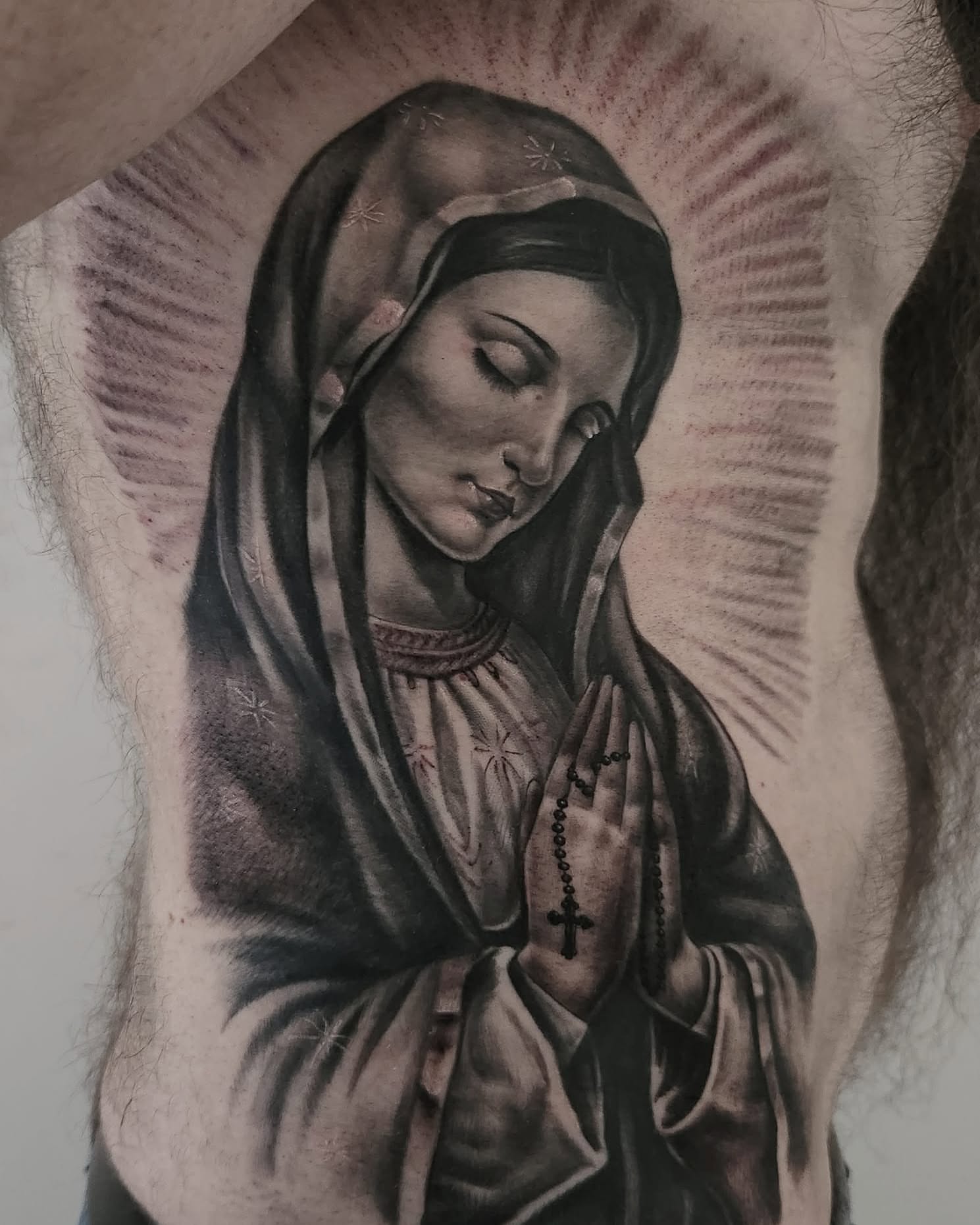 Praying woman realism tattoo on the upper arm by Elidia Veliz