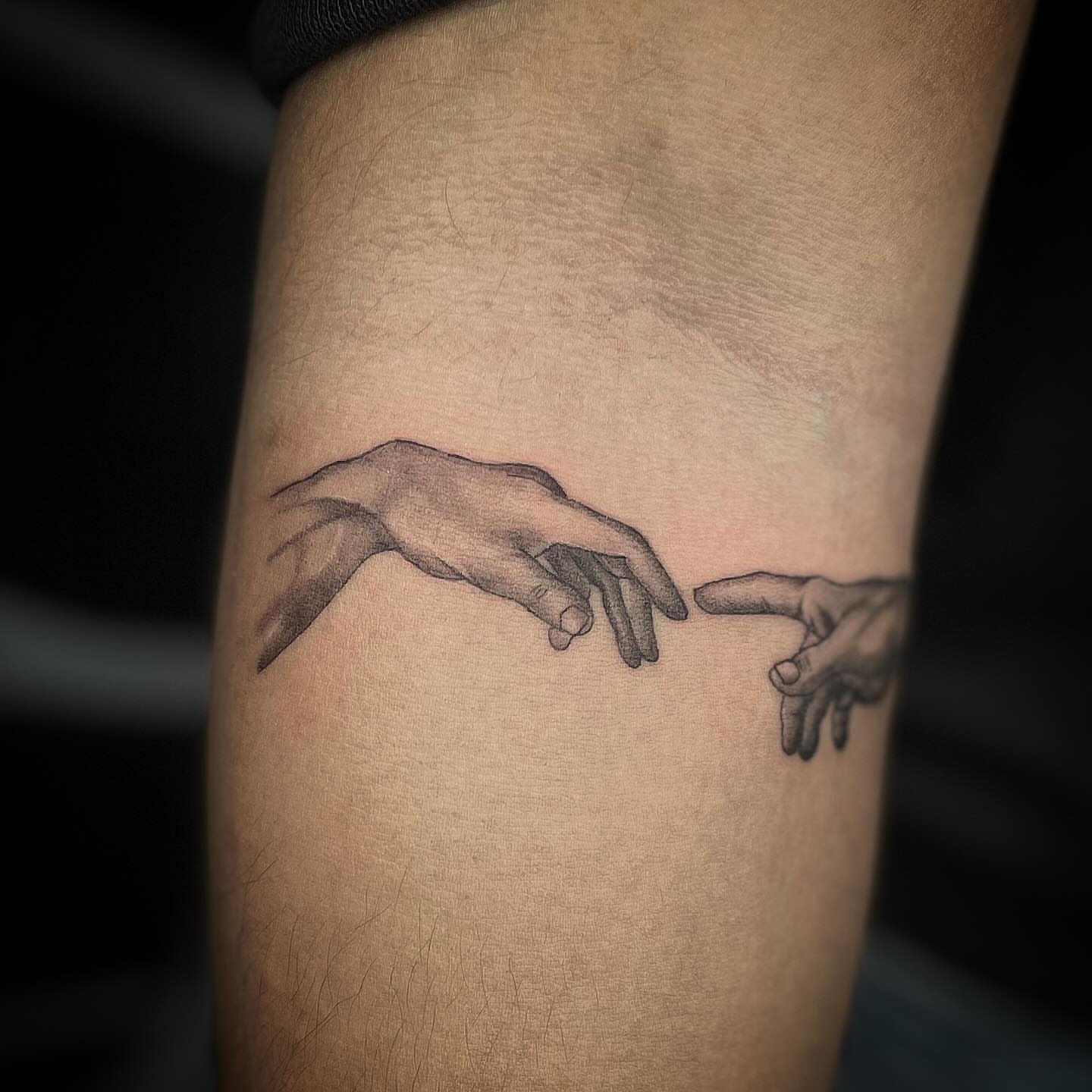 Touching hands black and grey tattoo on the forearm by Las Vegas Tattoo Artist
