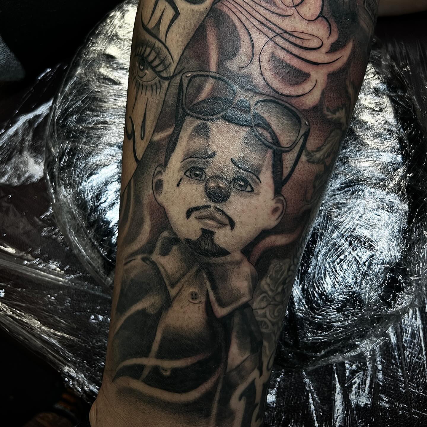 Man with mustache black and grey tattoo on the forearm by Joey Moreno