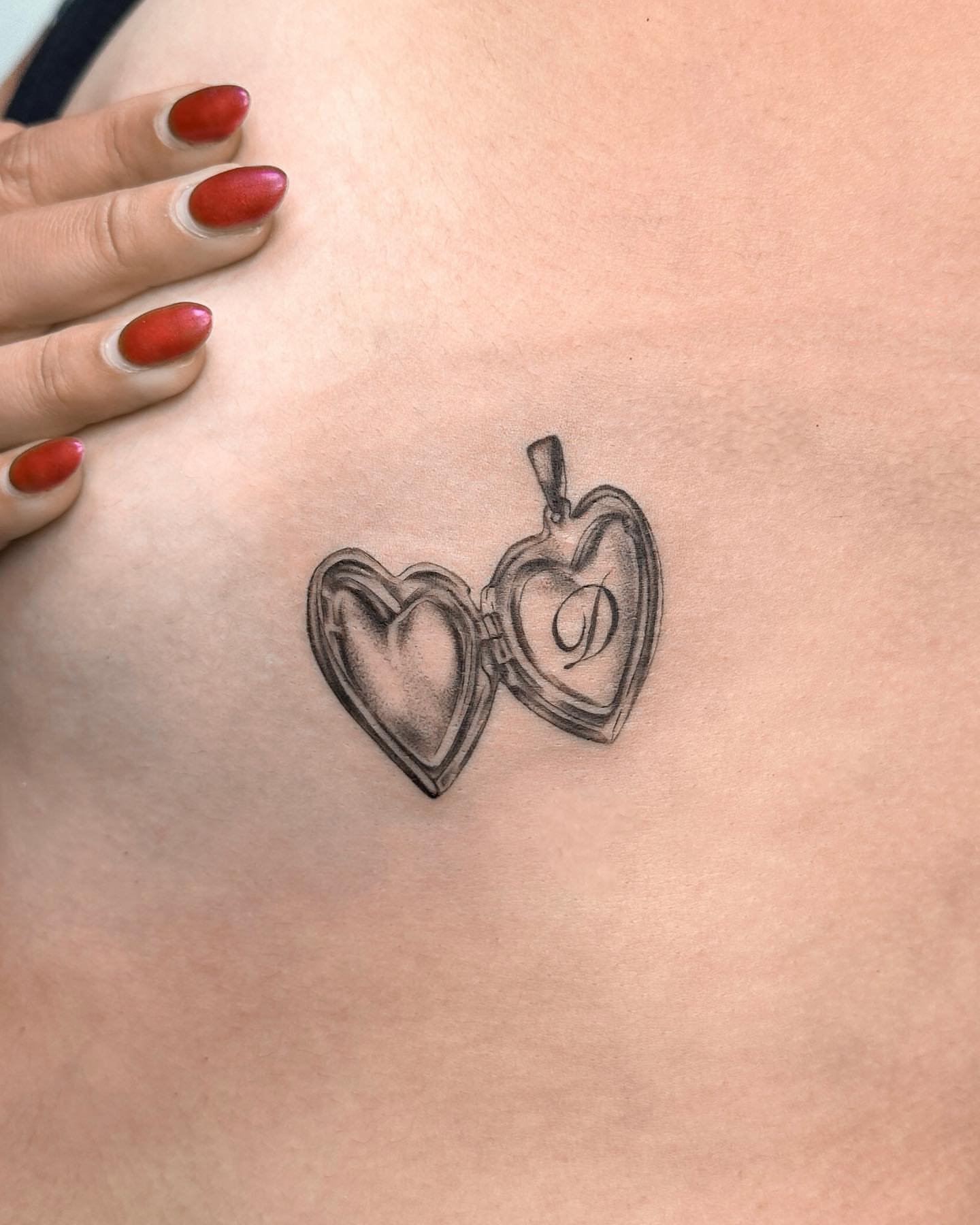Heart locket black and grey tattoo on the chest by Valery Cardona