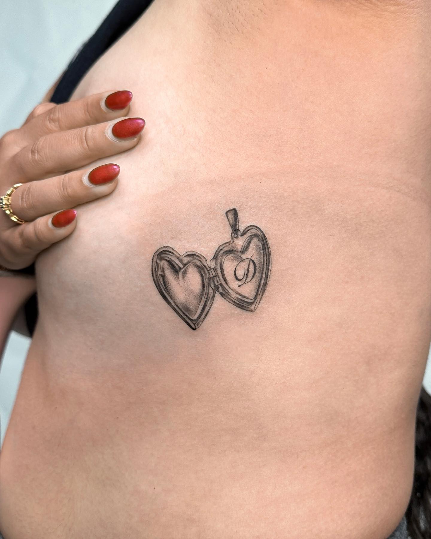 Heart-shaped locket black and grey tattoo on the chest by Valery Cardona