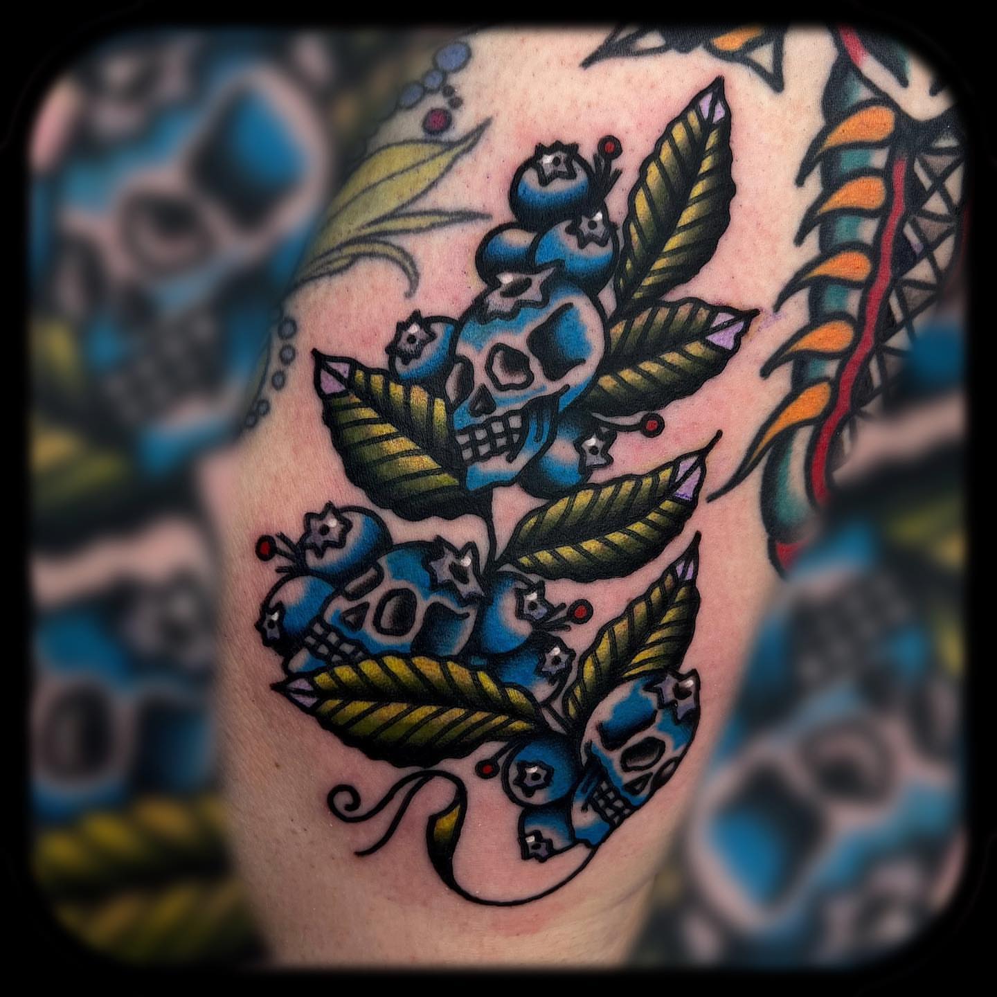 Blueberries and skulls American traditional tattoo on the shoulder by Benjamin Ward