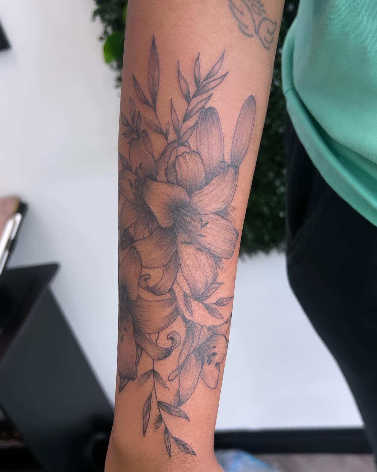 Floral arrangement black and grey tattoo on the forearm by Syd Cheyenne