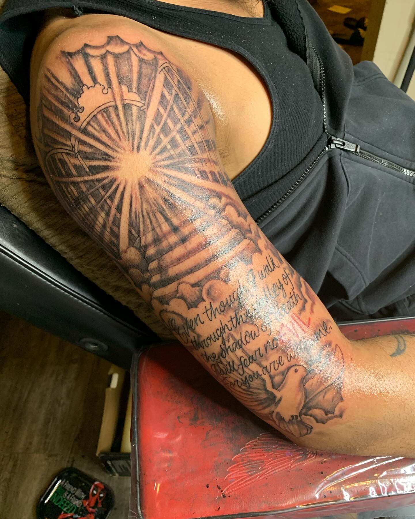Sunburst and dove black and grey tattoo on the upper arm by Azaan (Zanye), Birmingham, Alabama