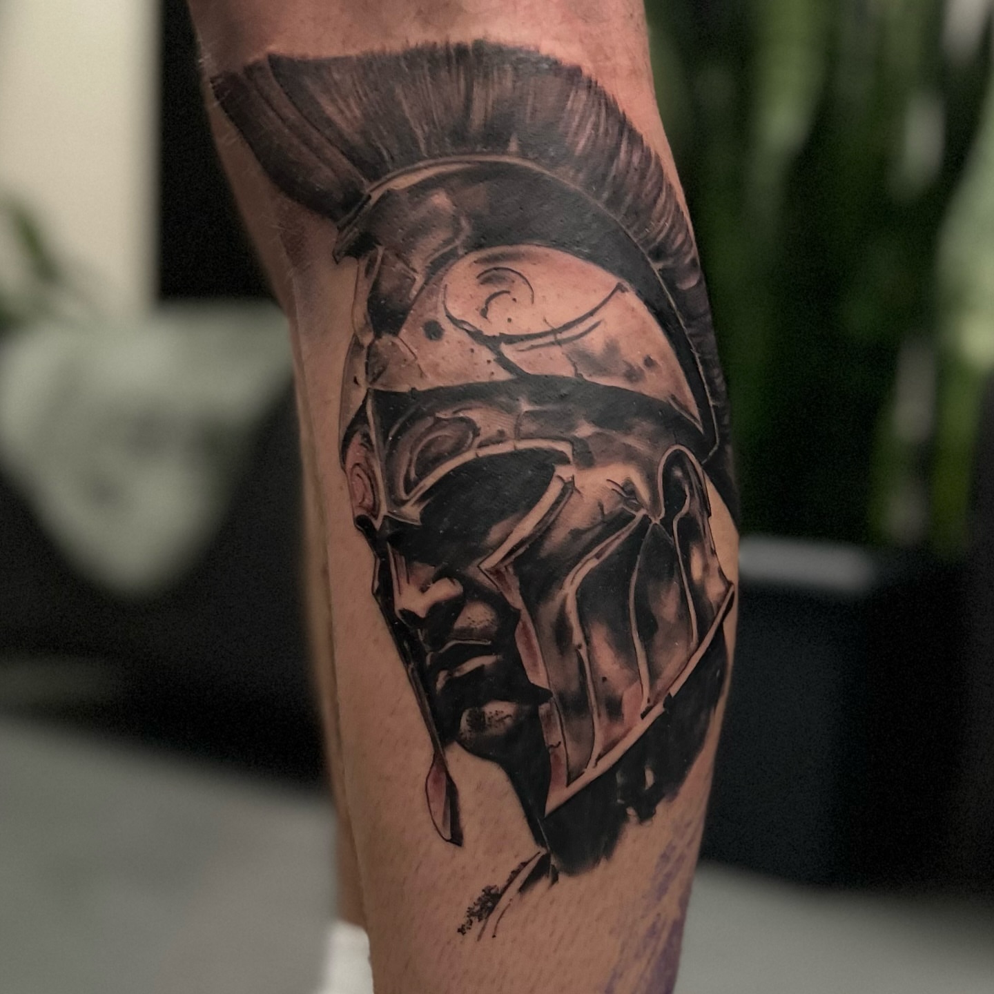 Spartan helmet black and grey tattoo on the forearm by Riki