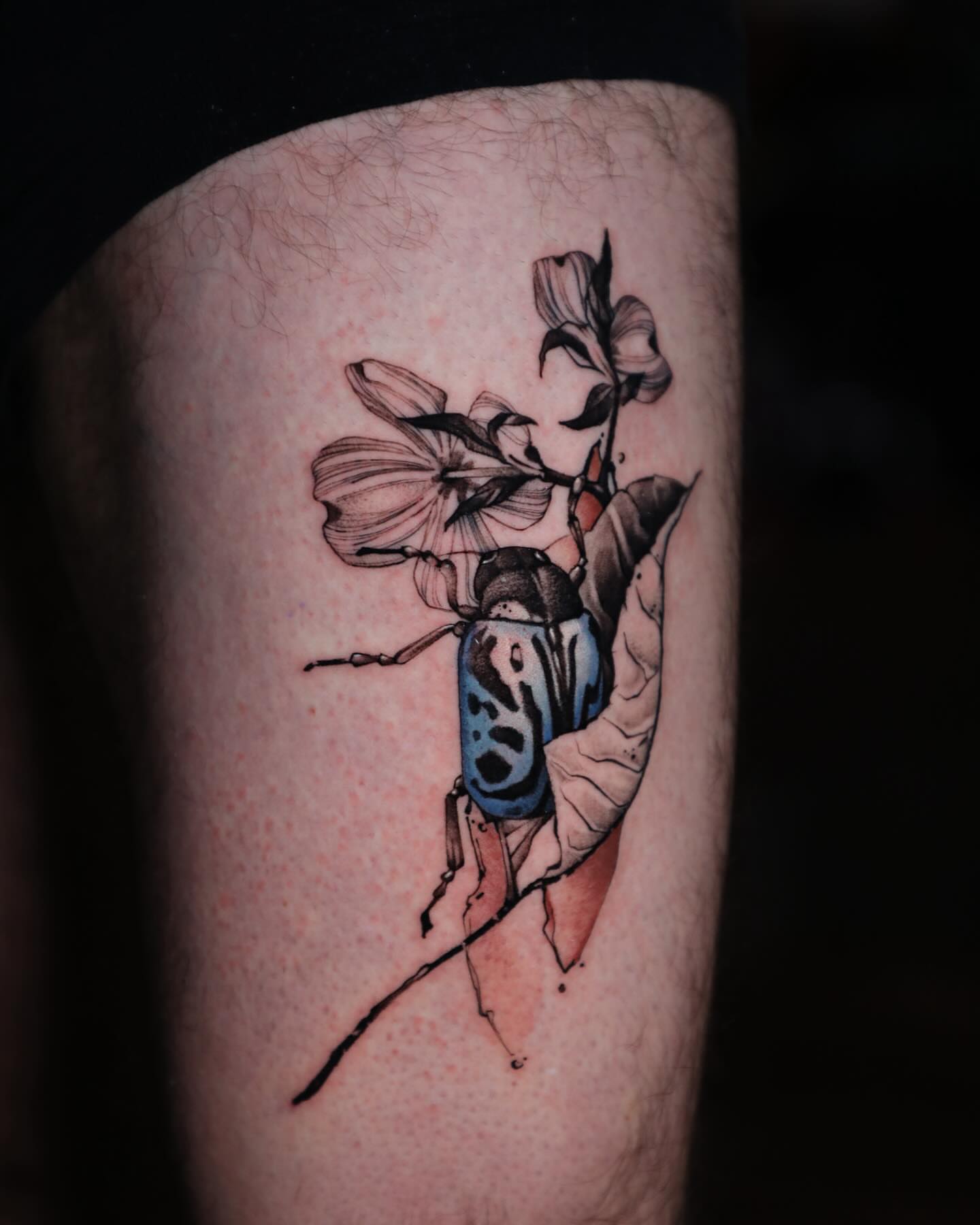 Beetle and flower realism tattoo on the thigh by Diego Romay