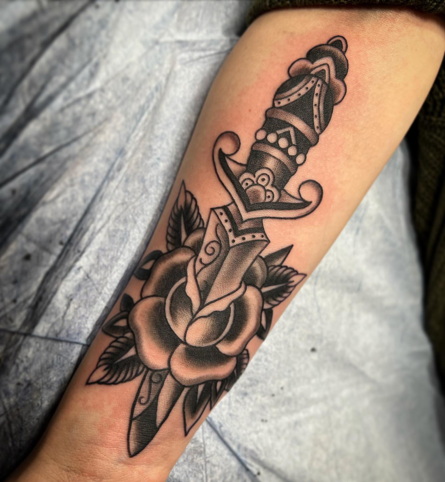 Rose and dagger American traditional tattoo on the forearm by Dustin Hysell