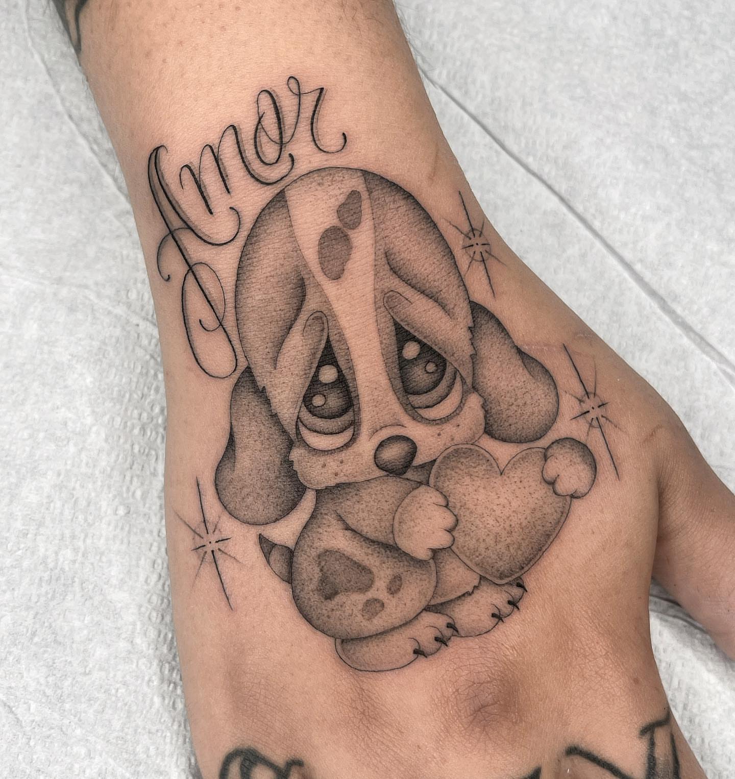 Sad puppy holding heart realism tattoo on the forearm by Tiyanna Garlic