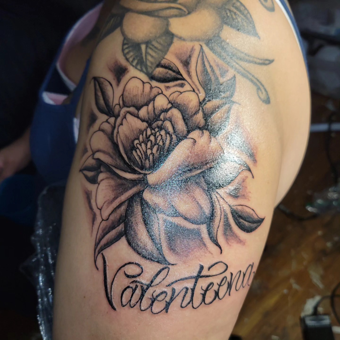 Flower black and grey tattoo on the upper arm by Markus Hicks