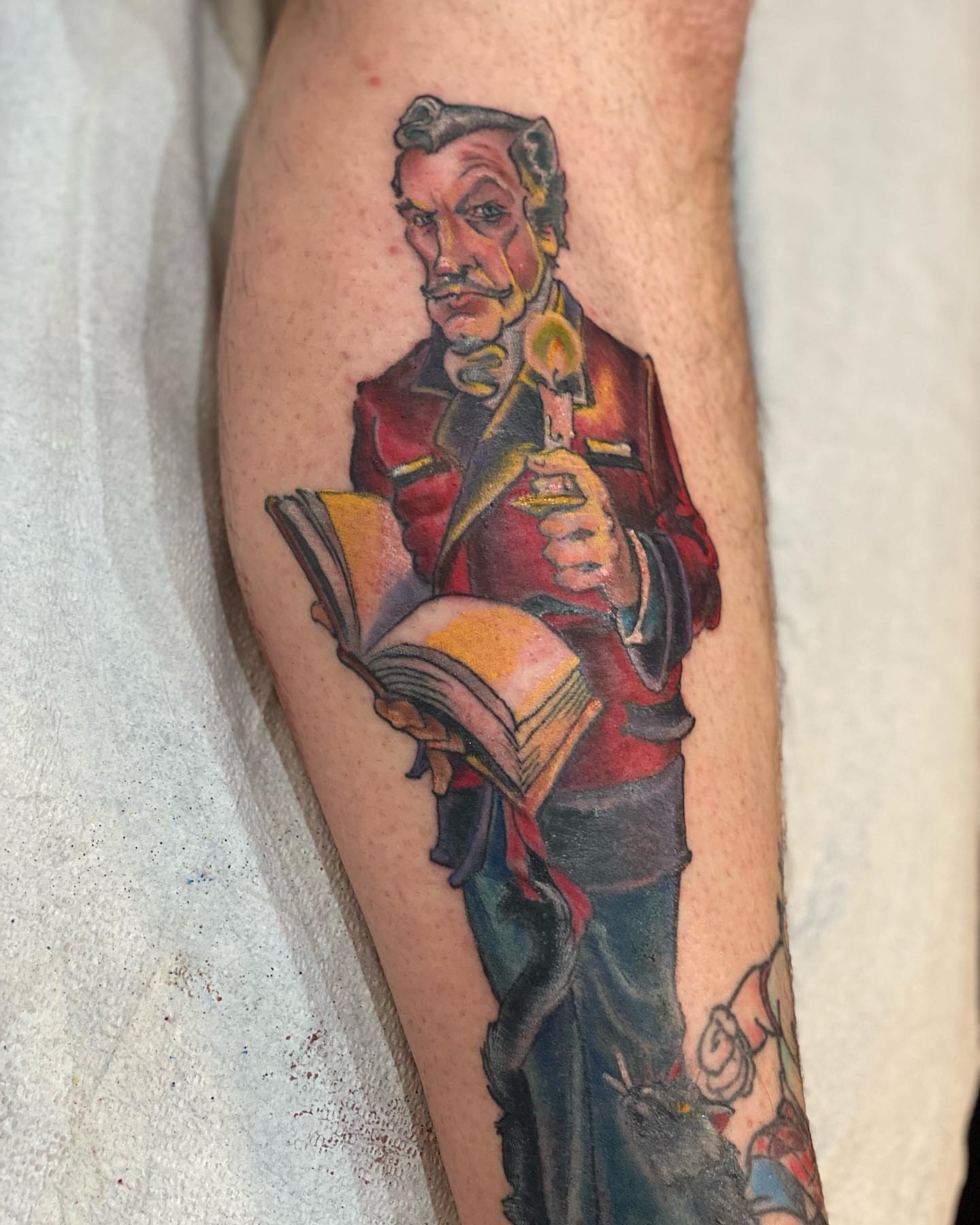 Man reading book realism tattoo on the forearm by Christopher Sanders