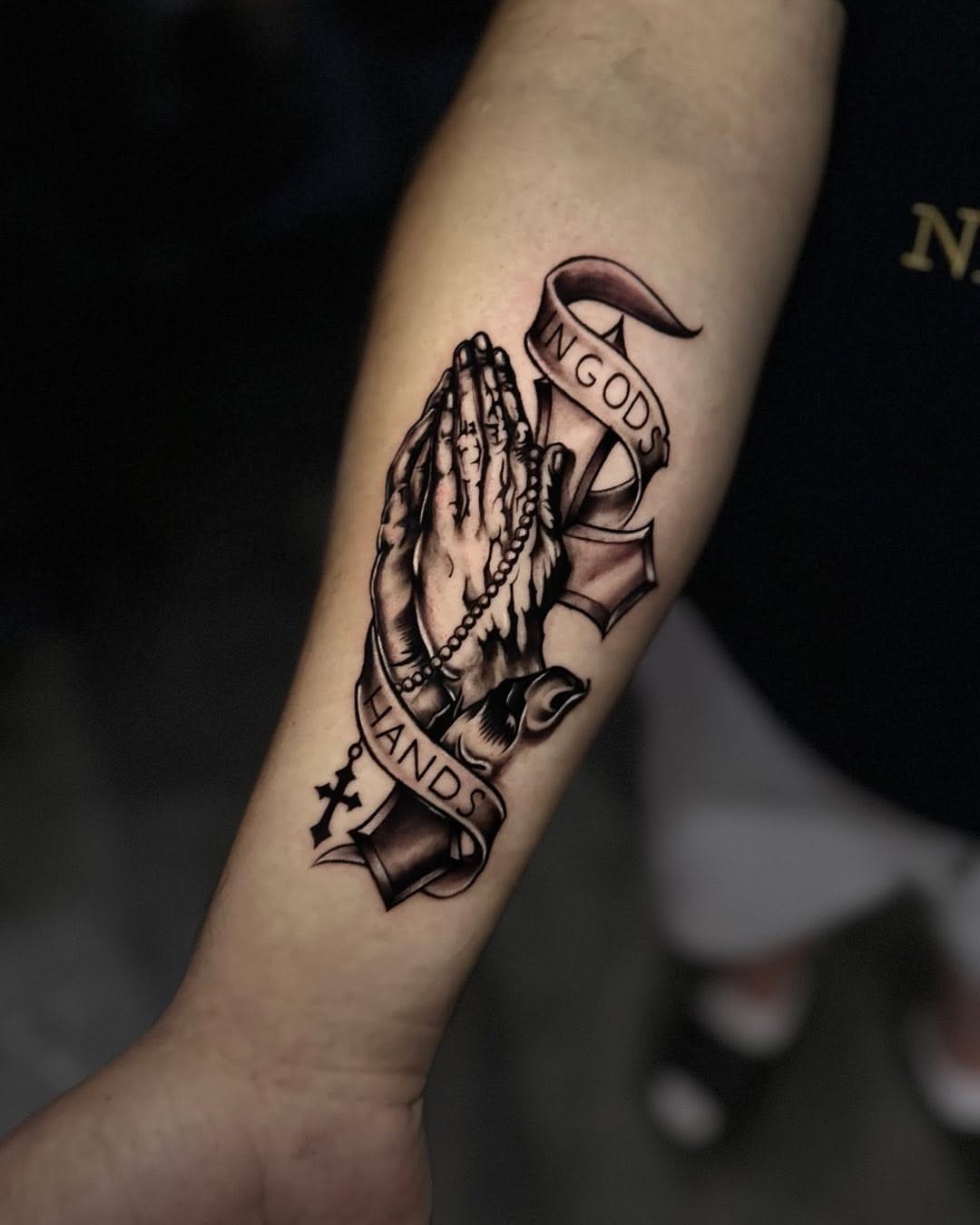 Praying hands American traditional tattoo on the forearm by Angel Gonzalez