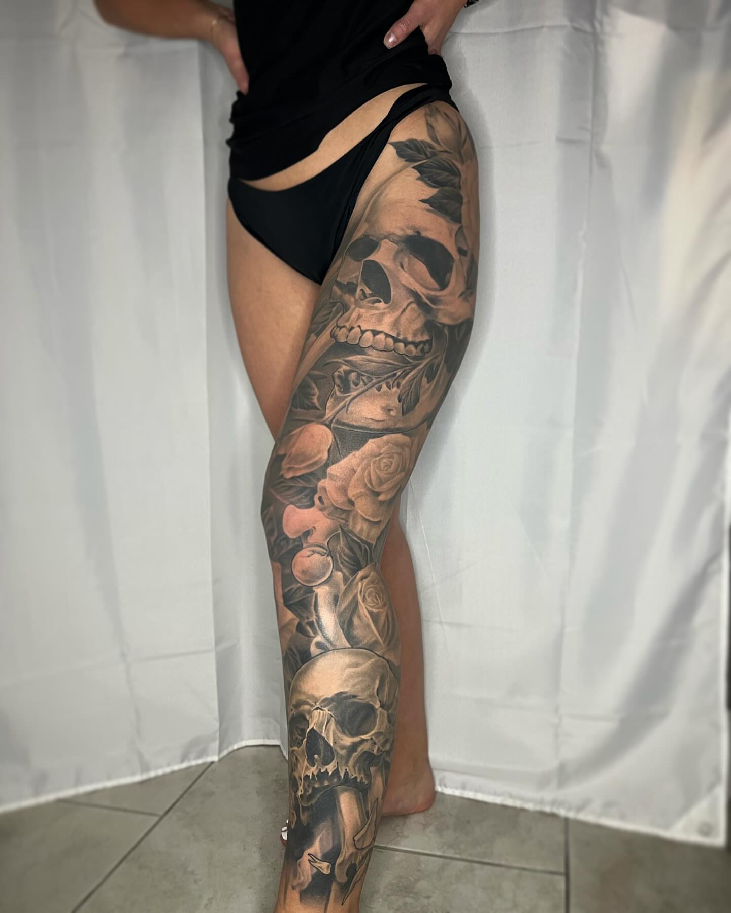 Skulls and roses realism tattoo on the leg by biggstattoos