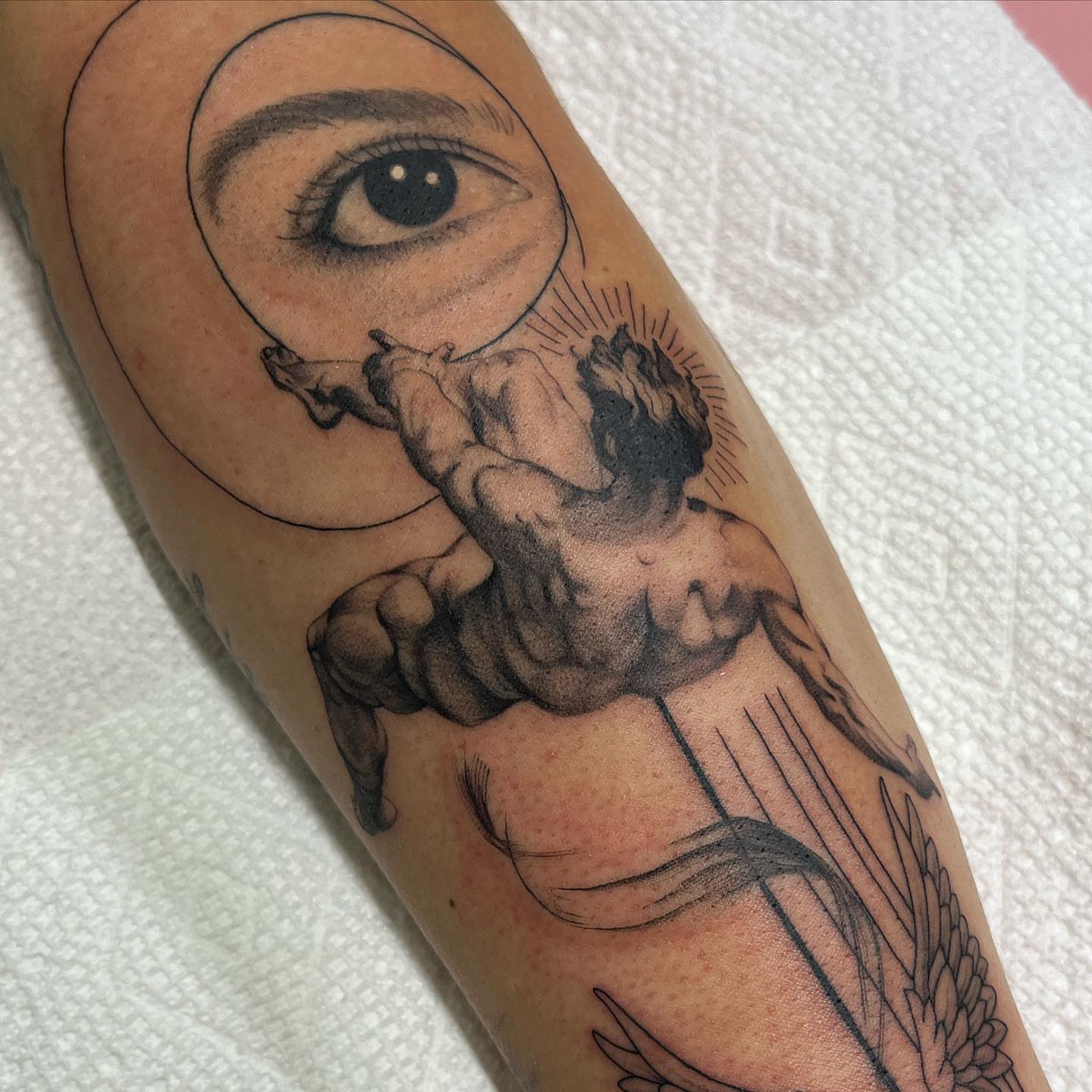 Angel with magnifying glass black and grey tattoo on the forearm by liliana lopez