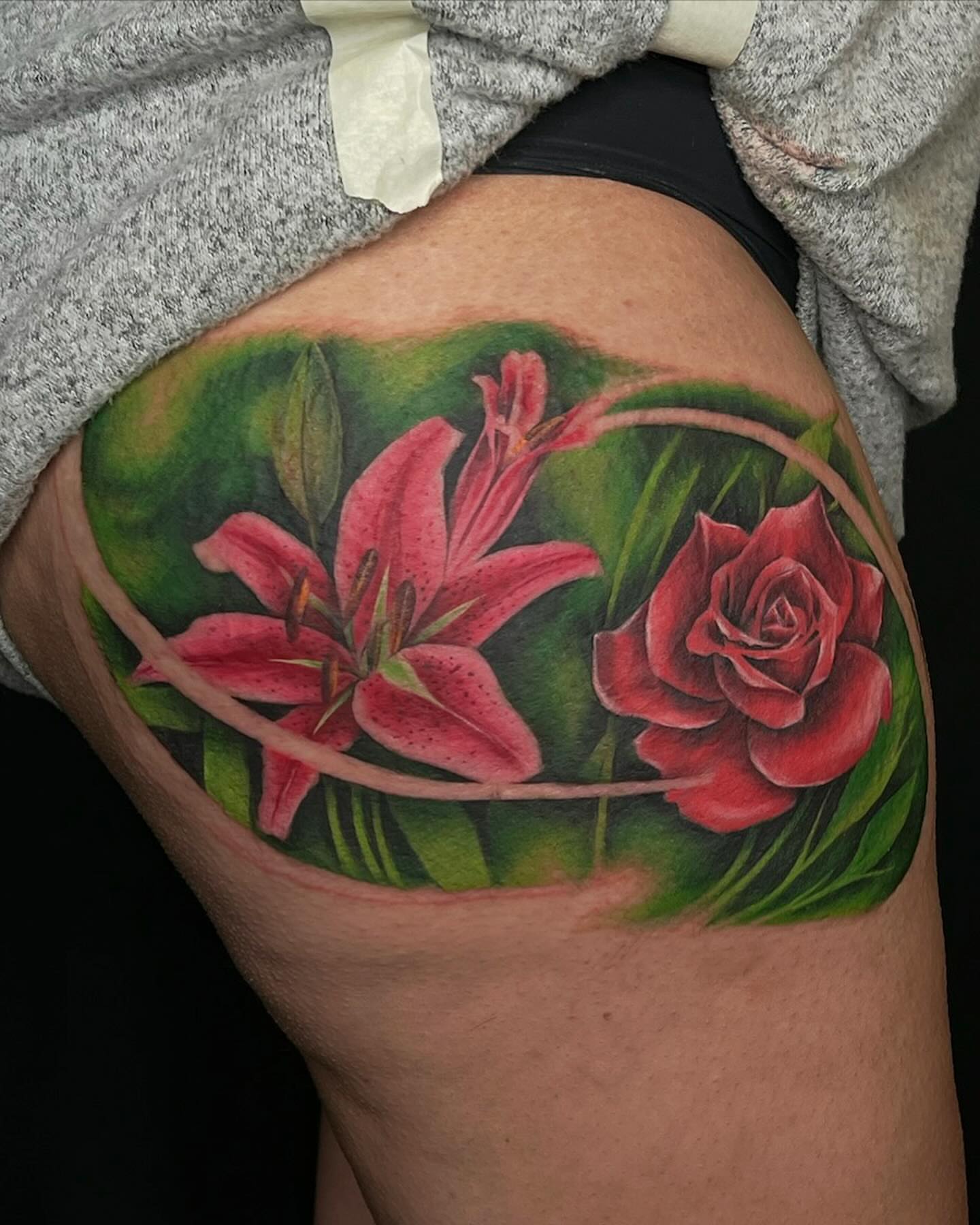 Lilies and rose realism tattoo on the thigh by Saint Jimmy