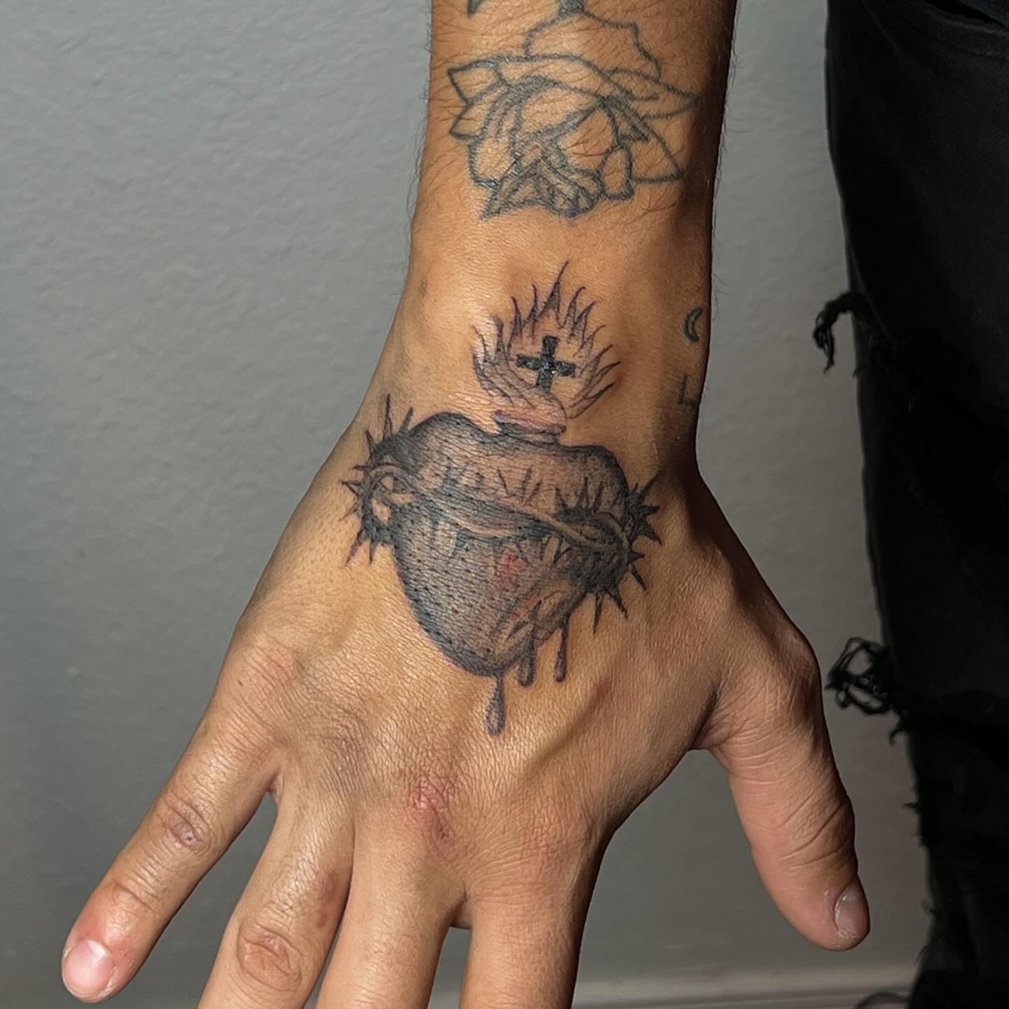 Heart with crown of thorns black and grey tattoo on the hand by josselyn ☪︎
