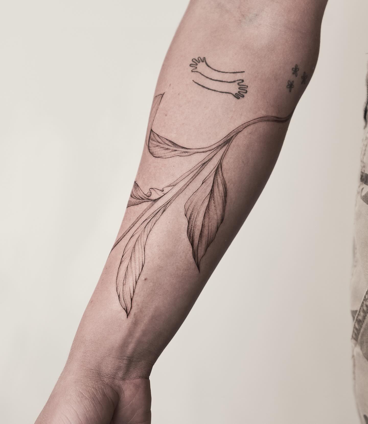 Feather black and grey tattoo on the forearm by Tattoo artist LA ། Fine line, Micro realism