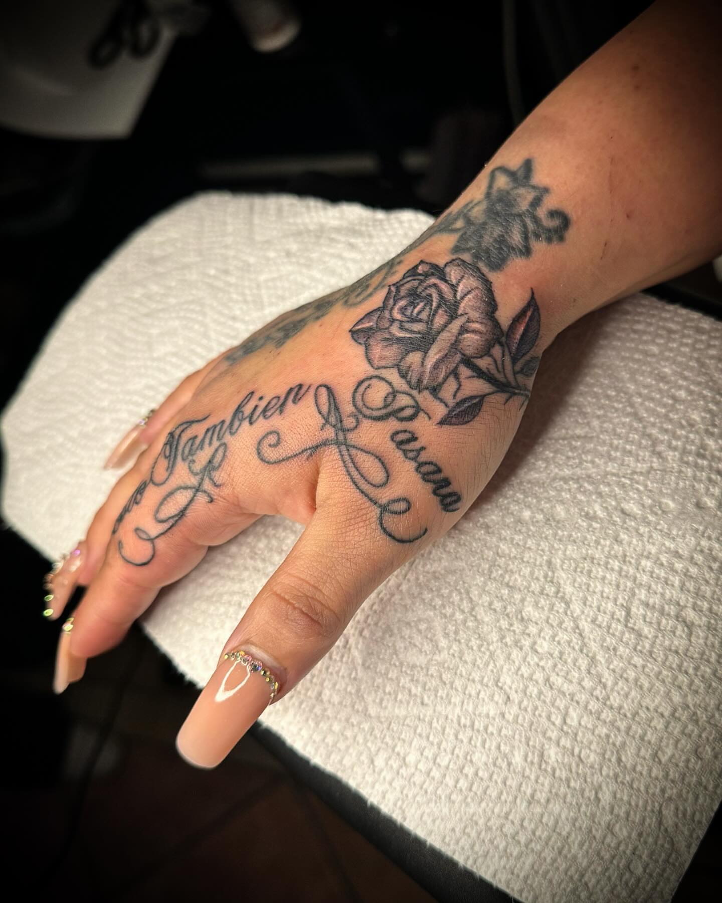 Rose and script American traditional tattoo on the hand by Tattoo Artist based in Dallas Tx