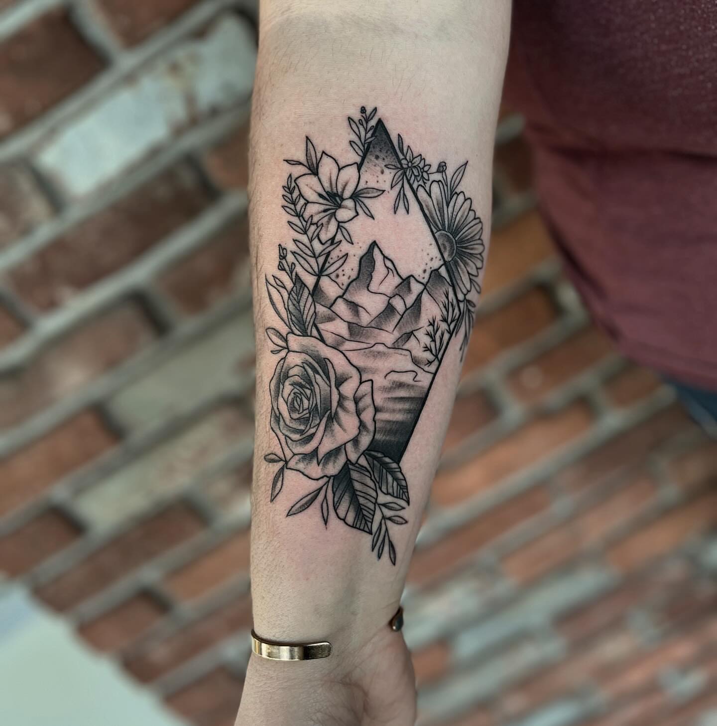 Mountain and floral bouquet geometric tattoo on the forearm by Aaron Carey, Salem, Oregon