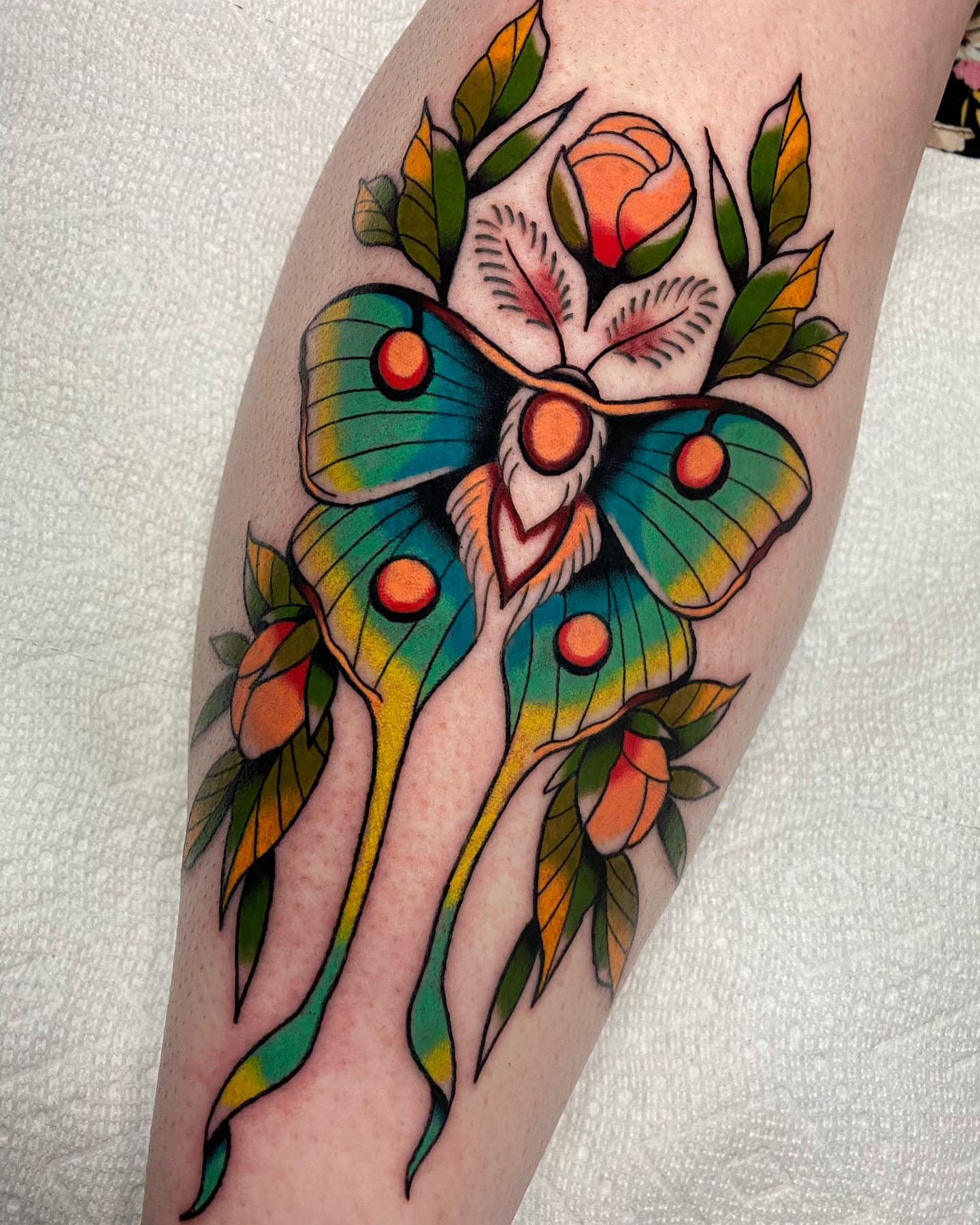 Butterfly and flowers American traditional tattoo on the thigh by Mitch Hoggard