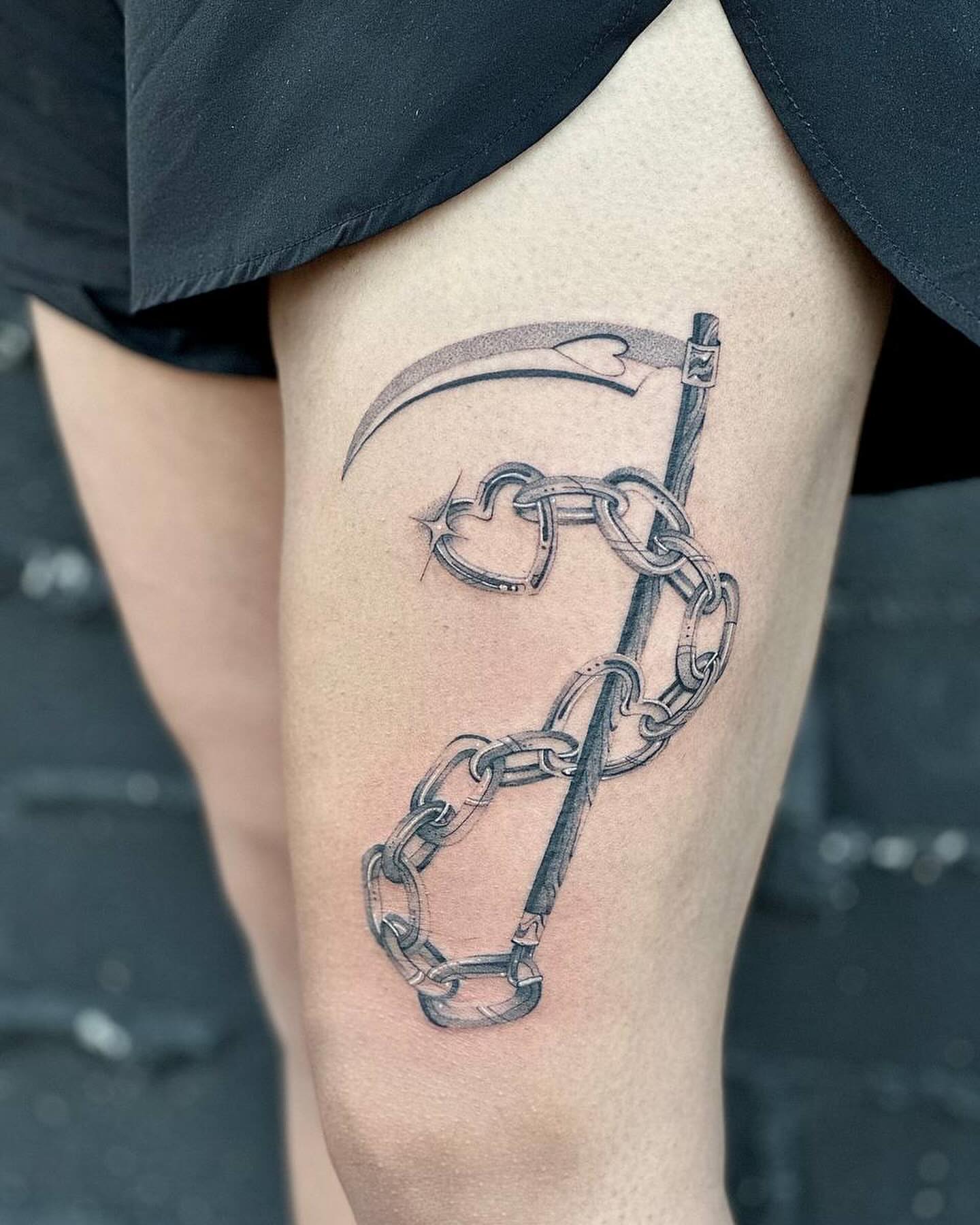 Scythe and chain black and grey tattoo on the thigh by Fine line tattoo San Diego, San Diego, California