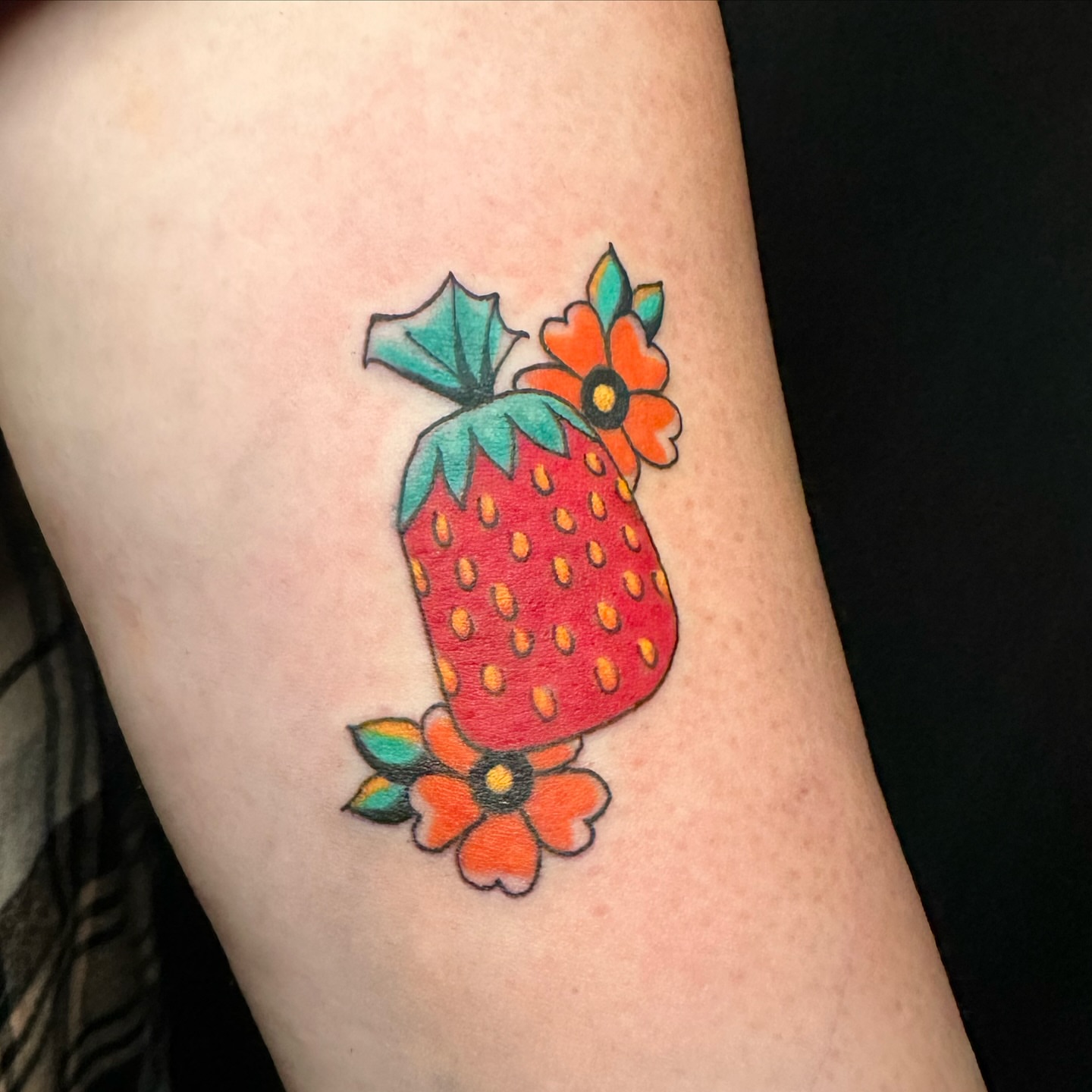 Strawberry and flowers new school tattoo on the forearm by vannadoestattoos