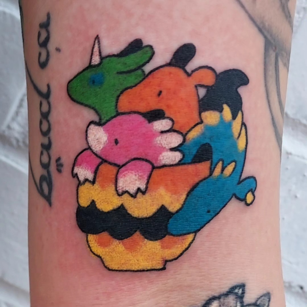 Colorful cartoon dragons dotwork tattoo on the forearm by Spike Cameron