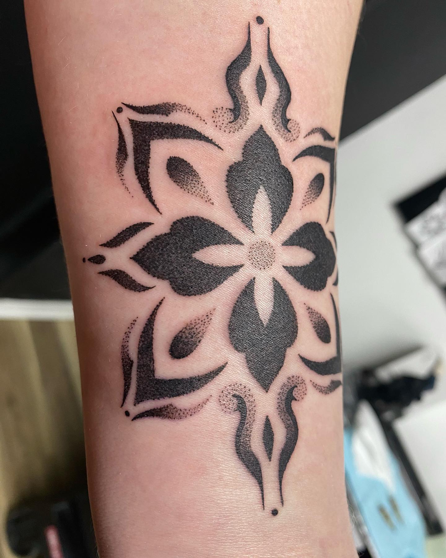 Floral design dotwork tattoo on the forearm by Rose Ulinski