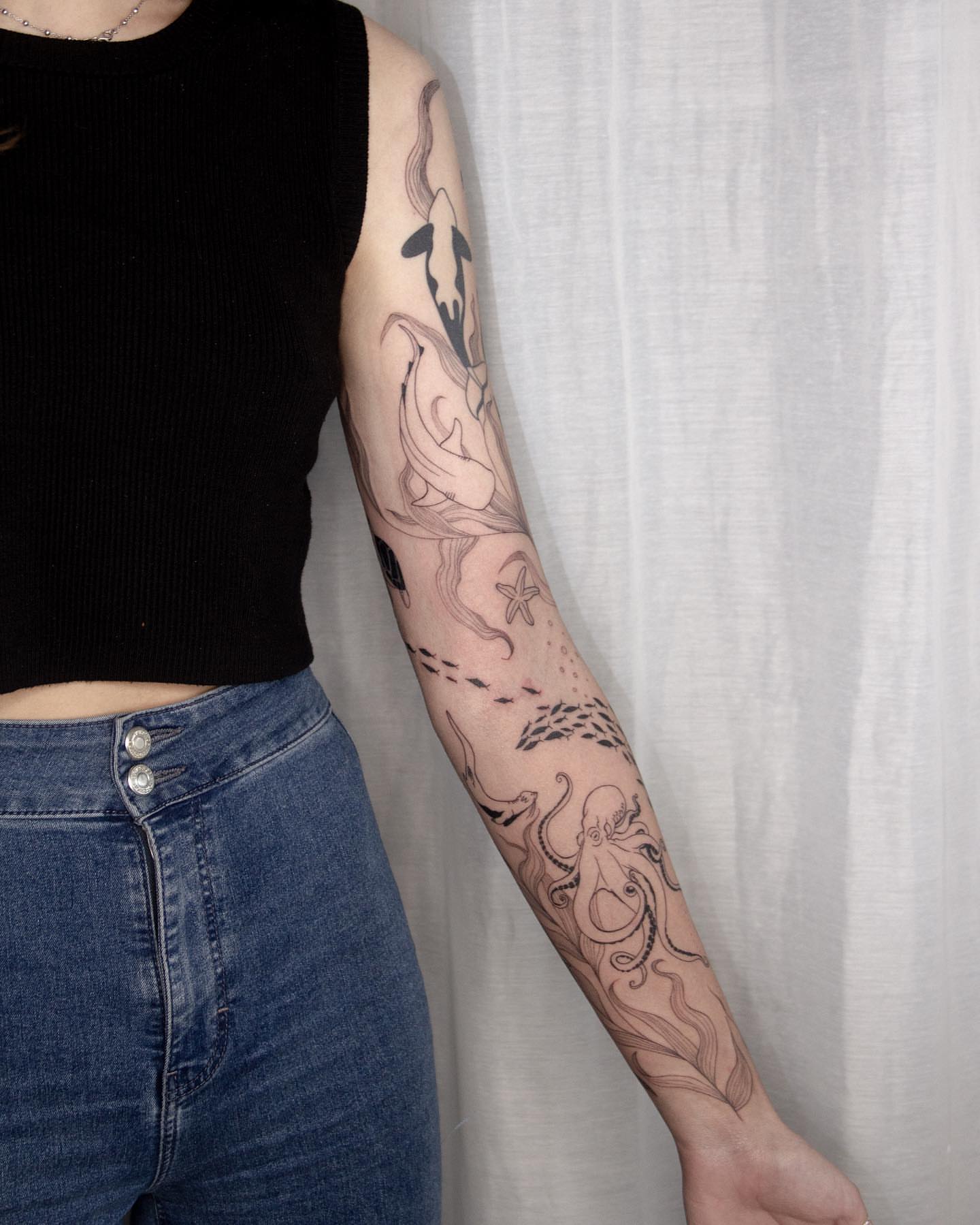 Octopus and dolphin realism tattoo on the forearm by Liv